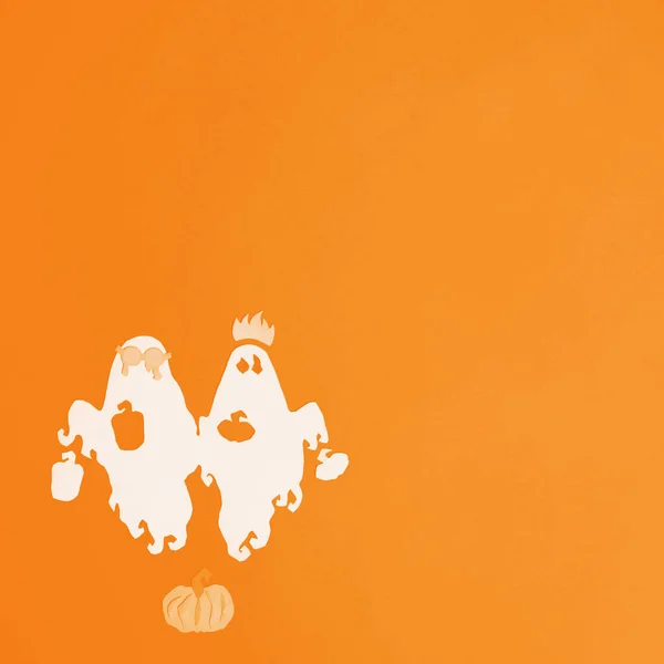 Призраки и тыквы вырезаны из белой бумаги на оранжевом фоне — стоковое фото