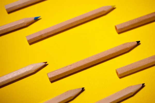 Pattern of colored pencils on a yellow background