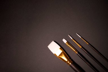 Gri arka planda resim yapmak için beyaz fırçalar.