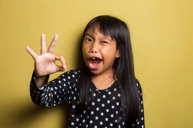 Asyalı küçük kız iyi bir el işareti gösteriyor.