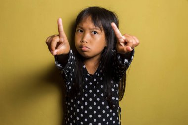 Asyalı küçük kız elleriyle dur hareketi yapıyor.