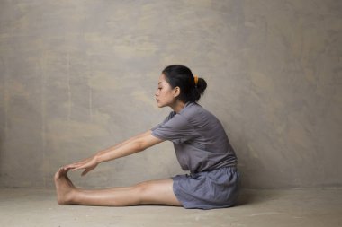 Formda ve genç Asyalı kadın portresi esneme hareketleri yapıyor.