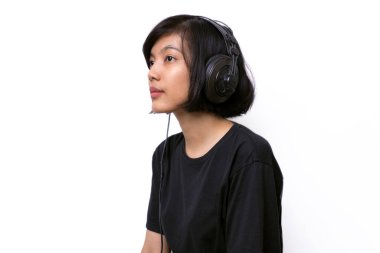 Beyaz arka planda izole edilmiş müzik stüdyosu çekimlerini dinleyen Asyalı kadın.