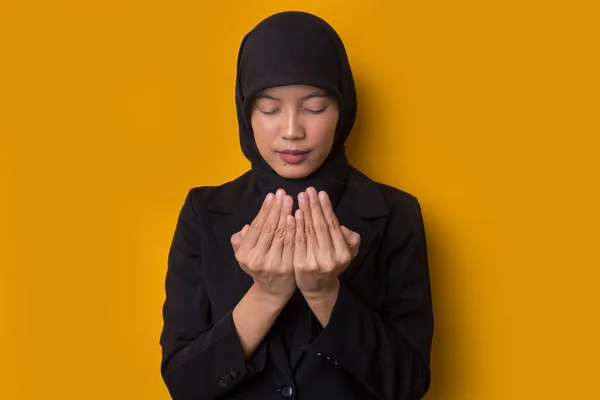 若いですアジアのイスラム教徒の女性とともにヒジャーブ礼拝上の黄色の背景 — ストック写真
