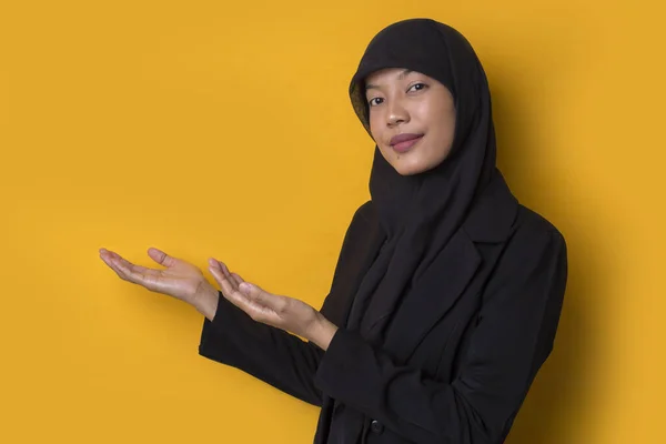 年轻的亚洲女商人戴着黄底头巾 带着自信的微笑 手指指向不同的方向 广告的复制空间 — 图库照片
