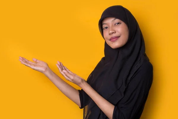 Sarı Arka Planda Tesettürlü Genç Asyalı Kadını Parmaklarıyla Farklı Yönleri — Stok fotoğraf