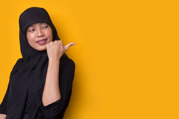 年轻的亚洲女商人戴着黄底头巾 带着自信的微笑 手指指向不同的方向 广告的复制空间 — 图库照片