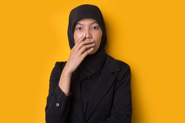 孤立した黄色の背景の上にヒジャーブを身に着けている若いアジアの女性は間違いのための手で口をカバーショックを受けた 秘密概念 — ストック写真