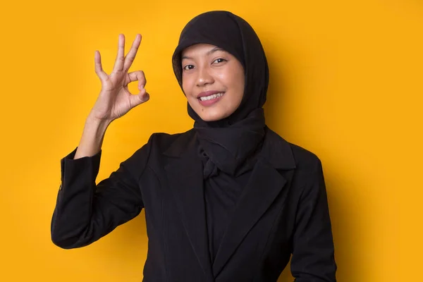 アジアのビジネス女性身に着けていますHijabとともに手親指アップ大丈夫上の黄色の背景 — ストック写真