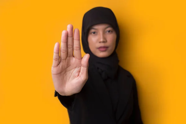 亚洲女人用孤立的手在黄色的背景上做停止动作 — 图库照片
