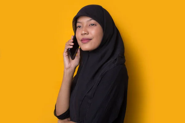 若いアジアのビジネス女性を身に着けているヒジャーブを身に着けている黄色の背景に電話で話す — ストック写真