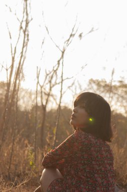 Genç kadın rahatlatıcı yaz günbatımı gökyüzü açık.