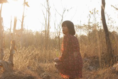 Genç kadın rahatlatıcı yaz günbatımı gökyüzü açık.