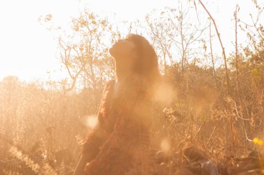 Genç kadın rahatlatıcı yaz günbatımı gökyüzü açık.