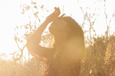 Genç kadın rahatlatıcı yaz günbatımı gökyüzü açık.