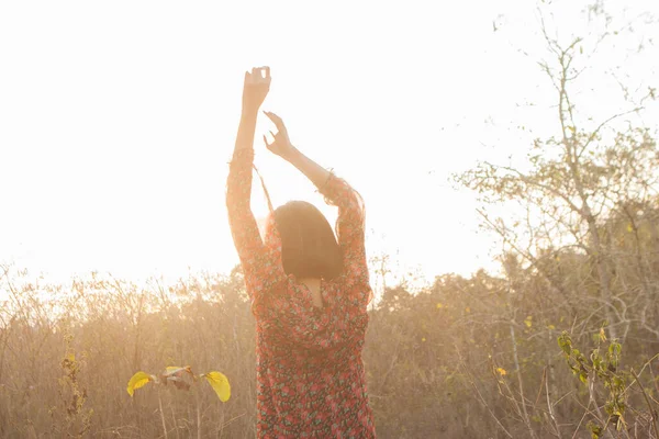 Genç kadın rahatlatıcı yaz günbatımı gökyüzü açık.
