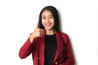 Genç Asyalı kadın gülümsüyor ve el hareketleriyle işaret veriyor..