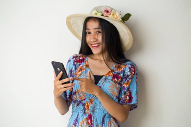 Telefonda konuşan Asyalı kadın turist beyaz arka planda izole edilmiş.