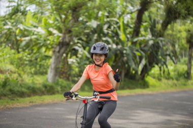 Güzel Asyalı bisikletçi. Parmaklarıyla imza atıyor.