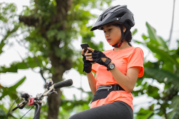 아시아인 자전거 선수들은 숲에서 자전거를 스마트폰을 — 스톡 사진