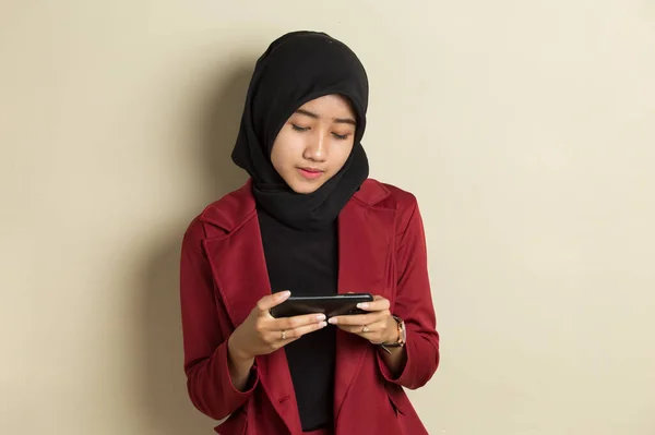快乐的亚洲穆斯林女人很兴奋用她的智能手机玩游戏 — 图库照片