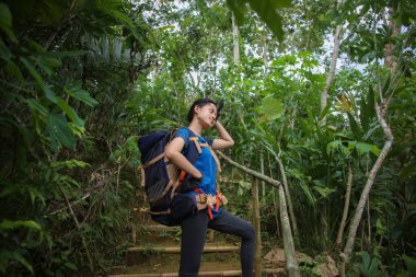 Asyalı kadın yürüyüş yaparken mola veriyor.