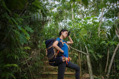 Asyalı kadın yürüyüş yaparken mola veriyor.
