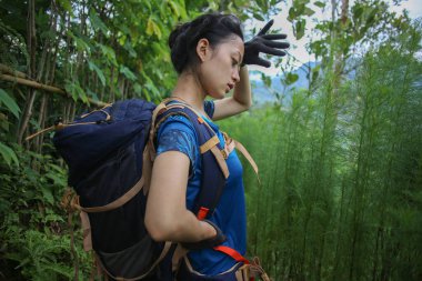 Asyalı kadın yürüyüş yaparken mola veriyor.