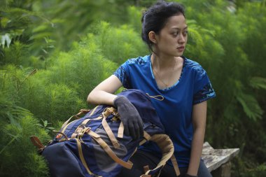 Asyalı kadın yürüyüş yaparken mola veriyor.