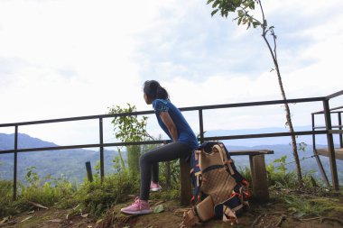 Asyalı kadın yürüyüş yaparken mola veriyor.