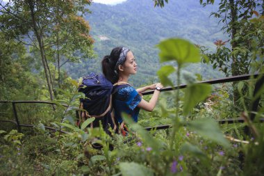 Sırt çantalı genç Asyalı kadın dağa tırmanıyor 