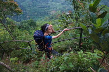 Sırt çantalı genç Asyalı kadın dağa tırmanıyor 