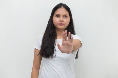 Asyalı kadın elleriyle dur hareketi yapıyor.
