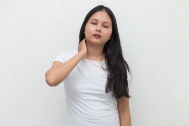 Boğazı ağrıyan Asyalı bir kadın boynuna dokunuyor. Boğazı ağrıyor.