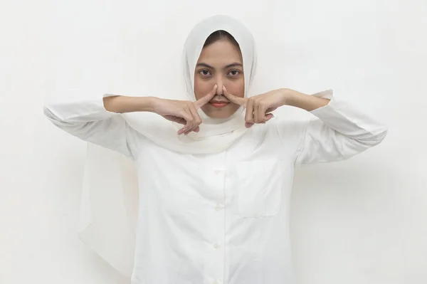 亚洲的穆斯林妇女因为闻到难闻的气味而捂住鼻子 — 图库照片