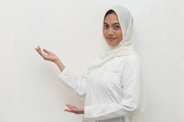 ヒジャーブを身に着けている若いアジアのイスラム教徒の女性は 異なる方向に指で自信を持って指して笑っている 広告のコピースペース — ストック写真