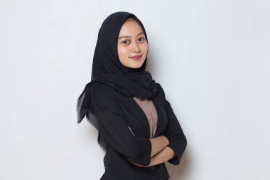 Asyalı genç Müslüman kadın, kollarını kavuşturmuş kaşkollu gülümseme.