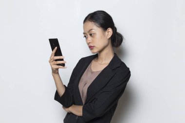 Genç Asyalı iş kadını beyaz arka planda izole cep telefonu kullanıyor.