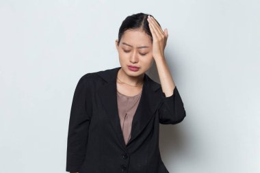 Beyaz arka planda baş ağrısı olan stresli bir iş kadını portresi.