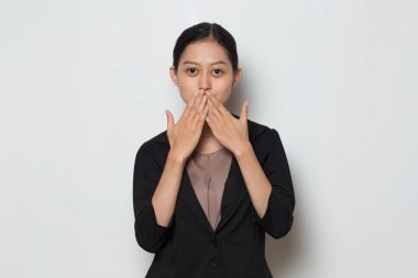 Asyalı genç bir iş kadını yanlışlıkla ağzını kapatırken şok oldu. Gizli konsept.