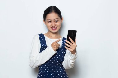 Beyaz arka planda izole edilmiş cep telefonu kullanan genç Asyalı kadın.