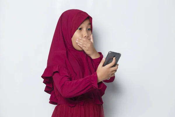 在白色背景下使用智能手机的休克穆斯林亚洲小女孩 — 图库照片