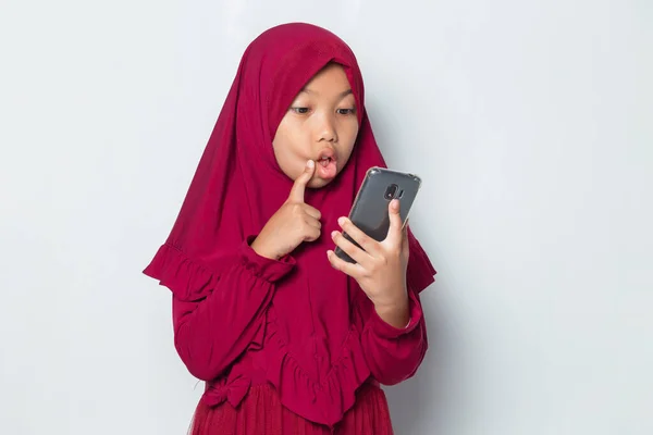 在白色背景下使用智能手机的休克穆斯林亚洲小女孩 — 图库照片