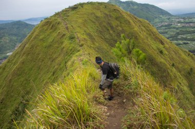 Sırt çantalı bir adam dağlarda tek başına seyahat ediyor.