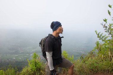 Sırt çantalı bir adam dağlarda tek başına seyahat ediyor.