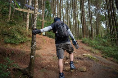 Sırt çantalı bir adam dağlarda tek başına seyahat ediyor.