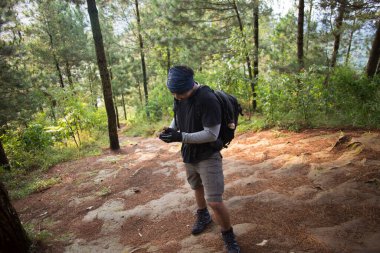 Sırt çantalı bir adam dağlarda tek başına seyahat ediyor.