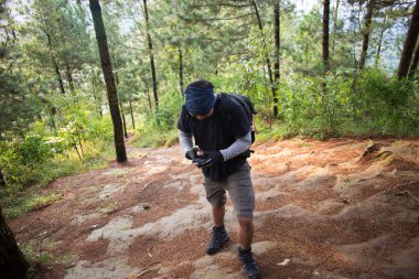 Sırt çantalı bir adam dağlarda tek başına seyahat ediyor.