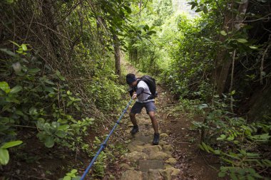 Sırt çantalı bir adam dağlarda tek başına seyahat ediyor. 