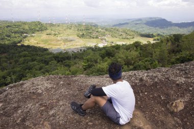 Sırt çantalı bir adam dağlarda tek başına seyahat ediyor. 